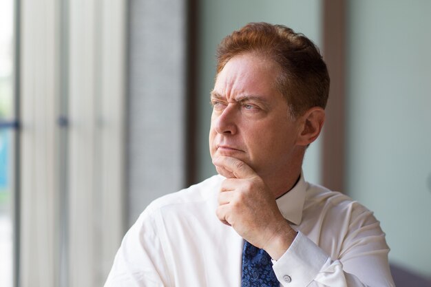 Thoughtful mature businessman looking aside