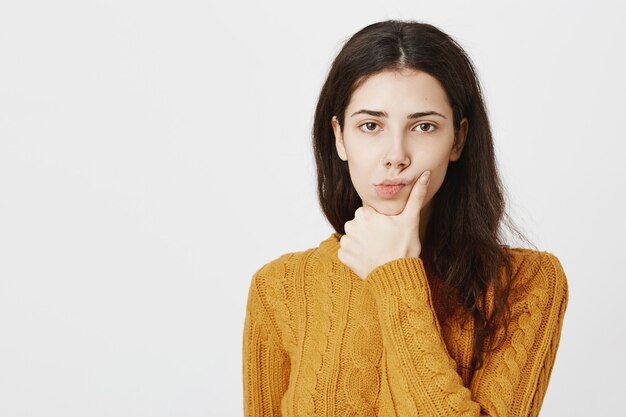 Ragazza ponderante premurosa che prende la decisione