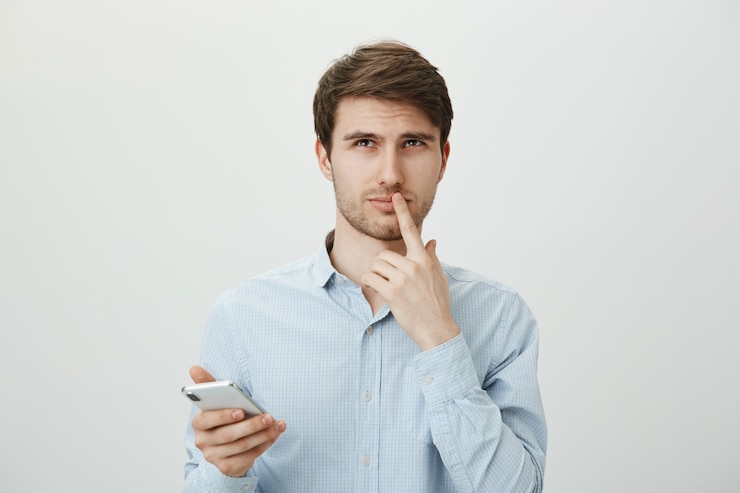 Free Photo thoughtful pondering man using mobile phone, look up thinking