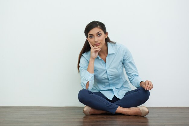 Thoughtful Pretty Woman on Floor in Lotus Pose