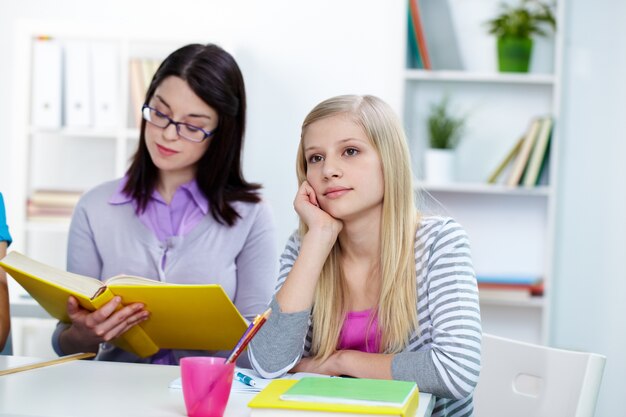 Thoughtful schoolgirl sitting at desk