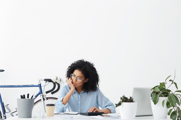 Free photo thoughtful serious professional worker female sitting in office