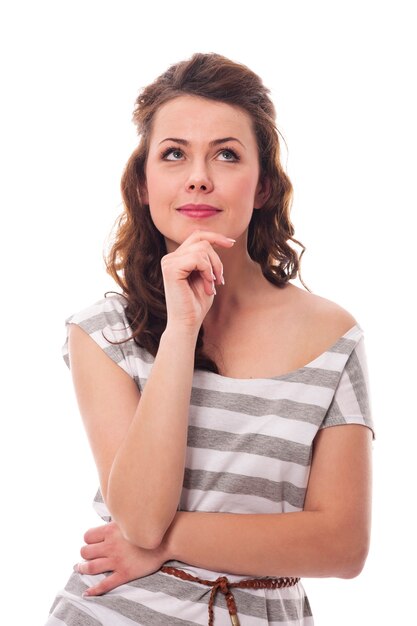 Thoughtful smiling woman looking up at copy space 
