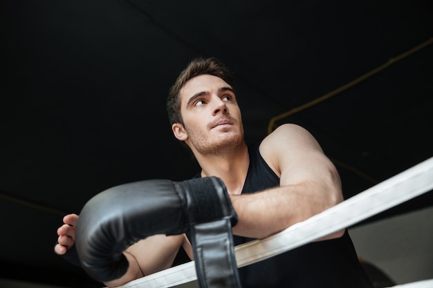Thoughtful sportsman standing on ring