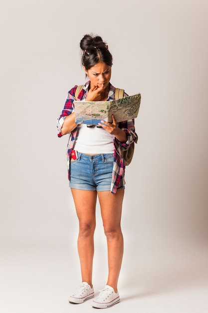 Foto gratuita pensierosa donna turistica guardando alla mappa