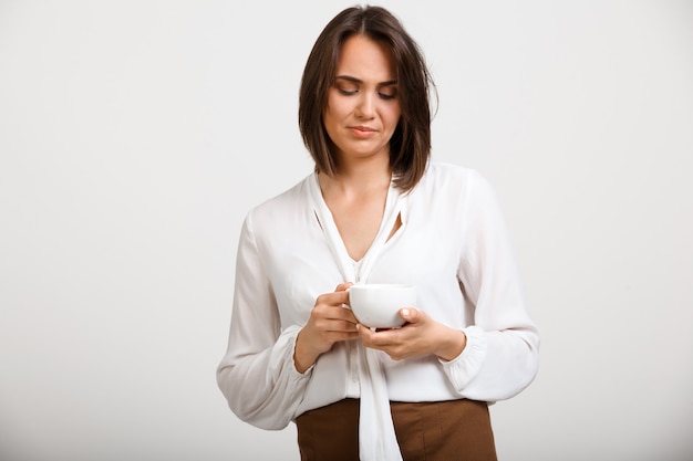 Foto gratuita donna di moda sconvolto pensieroso bere caffè, pensando