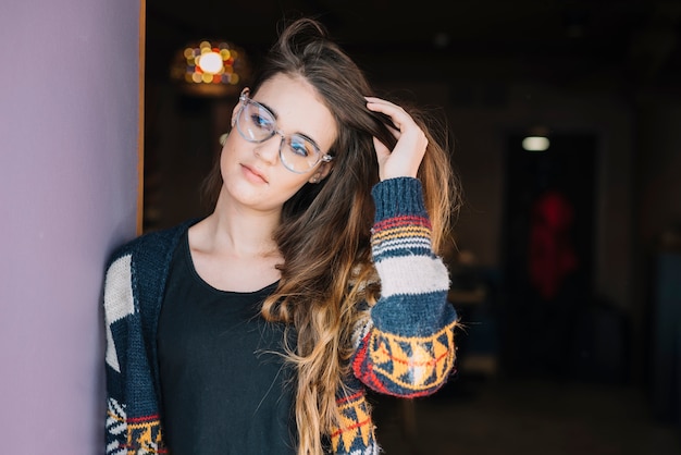 Foto gratuita donna premurosa in vetri che regolano capelli