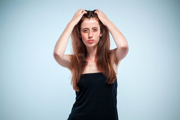 The thoughtful woman on gray wall