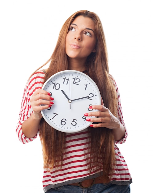 Free photo thoughtful woman holding a clock