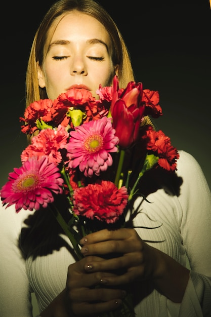 Thoughtful woman holding pink flowers bouquet 