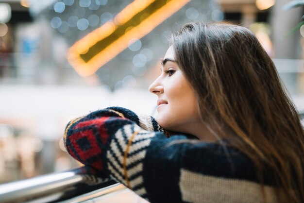 Thoughtful woman leaning on railing 