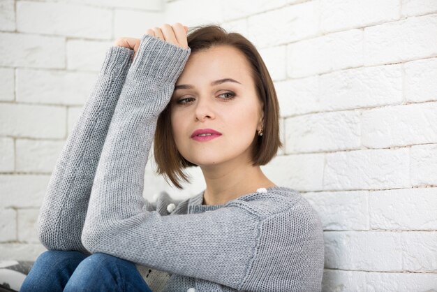 Thoughtful woman leaning on wall