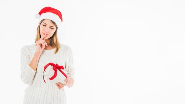 Thoughtful woman looking at small gift box