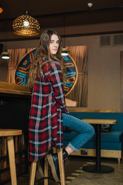 Thoughtful woman sitting on bar chair 