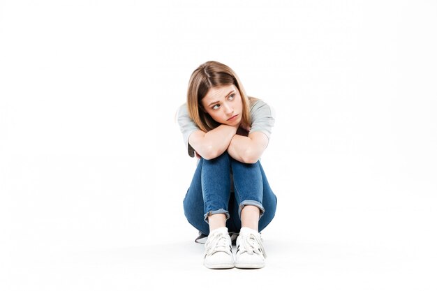 Thoughtful woman sitting cross-legged