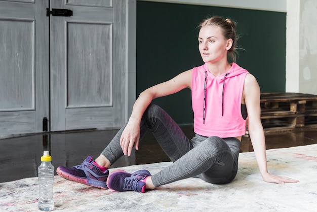 Free photo thoughtful woman sitting on floor relaxing