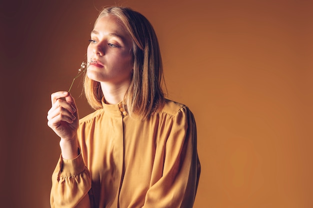 Free photo thoughtful woman smelling flower