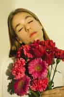 Free photo thoughtful woman with bright flowers bouquet