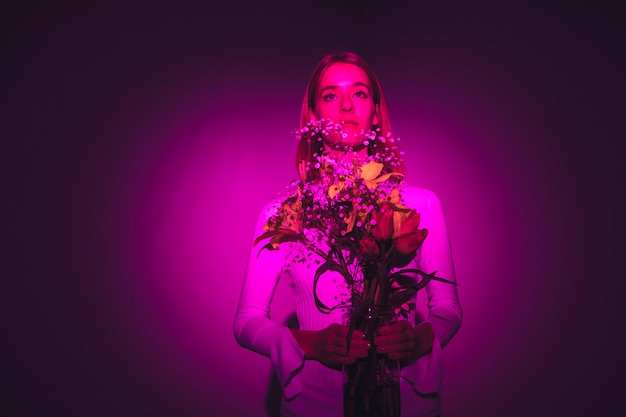 Free photo thoughtful woman with bright flowers in vase