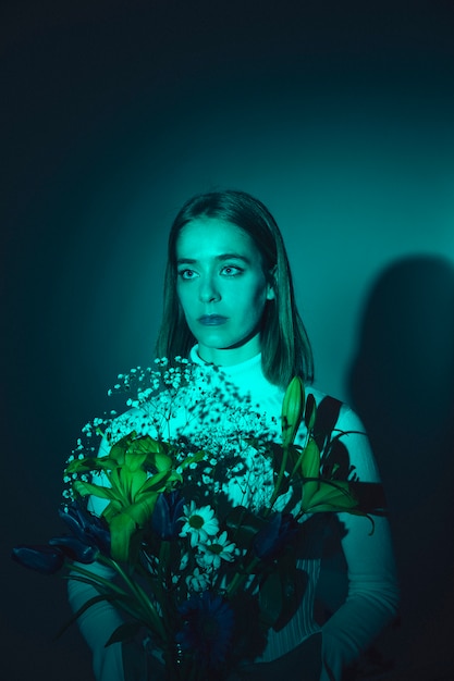 Thoughtful woman with bright flowers 