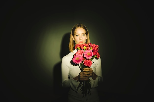 Thoughtful woman with flowers bouquet 