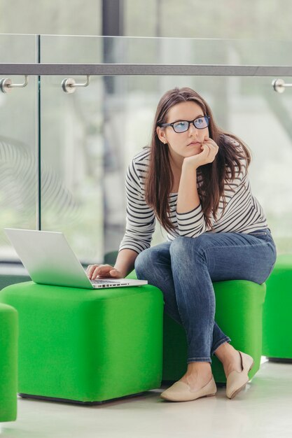 Thoughtful woman with laptop