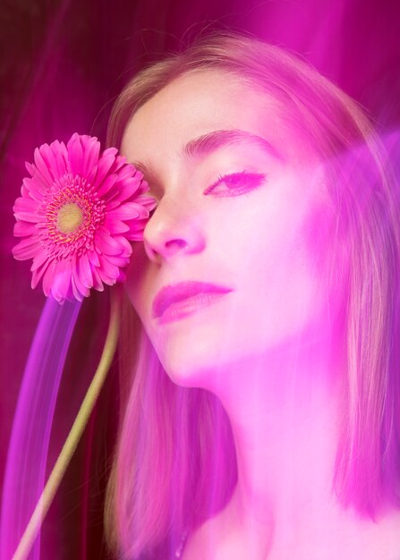 Thoughtful woman with pink gerbera