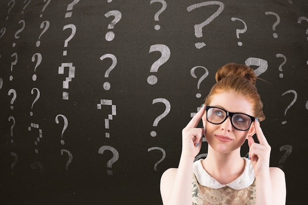 Thoughtful woman with question symbols behind