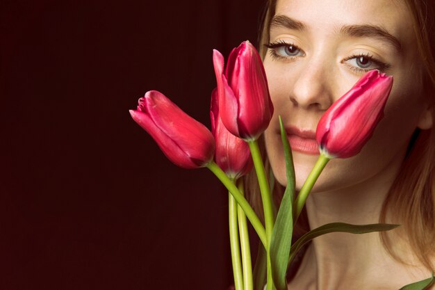 Thoughtful woman with red tulips