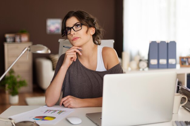 Thoughtful woman working at home