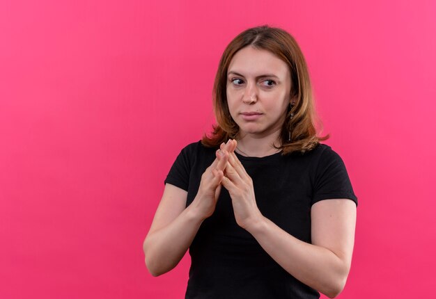 Задумчивая молодая повседневная женщина, складывающая руки на изолированной розовой стене с копией пространства