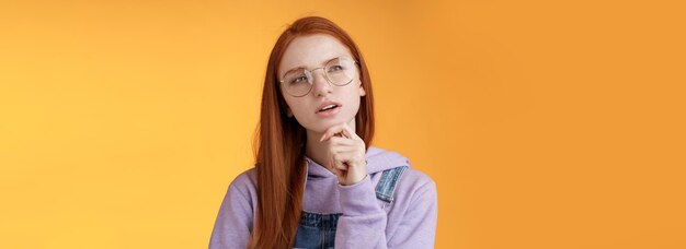 Free photo thoughtful young creative smart redhead girl thinking figure out important thing standing upper left