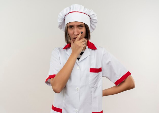 턱에 손을 넣어 요리사 유니폼에 사려 깊은 젊은 여성 요리사와 흰 벽에 고립 된 뒤에 다른 하나