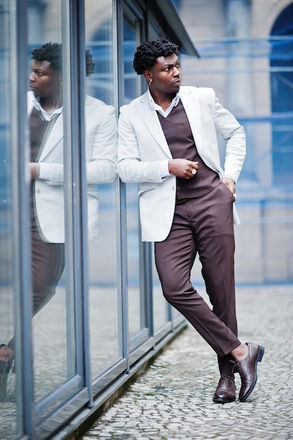 Premuroso giovane gentiluomo afroamericano bello in abbigliamento formale uomo nero modello elegante in giacca bianca