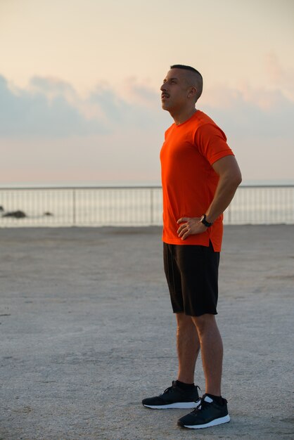 Thoughtful young male athlete standing outdoors