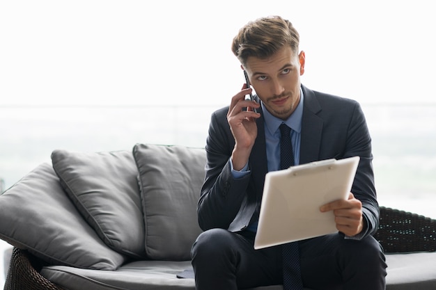 Thoughtful Young Man Discussing Business on Phone