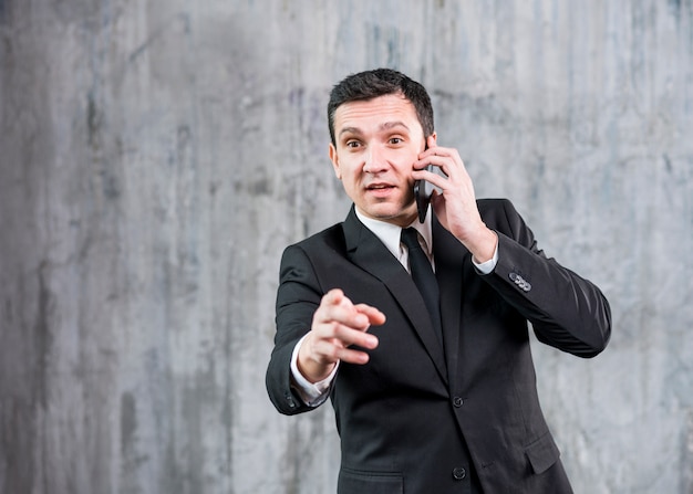 Free photo thoughtful young stylish businessman speaking on phone