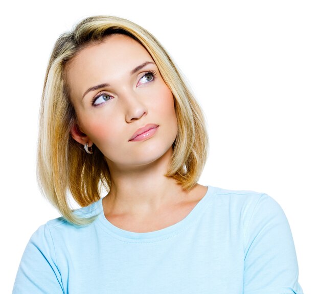 Thoughtful young woman looking up isolated on white