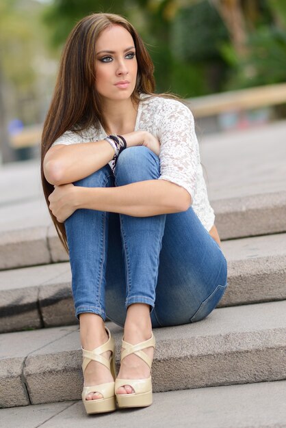 階段の上に座って思いやりがある若い女性