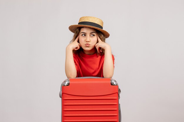 Free photo thpughtful holiday girl with her valise standing on white