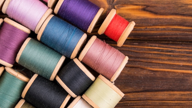 Thread spools on wood background