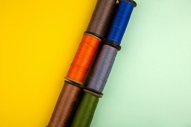 Free photo threads multicolored for sewing on a yellow-green floor