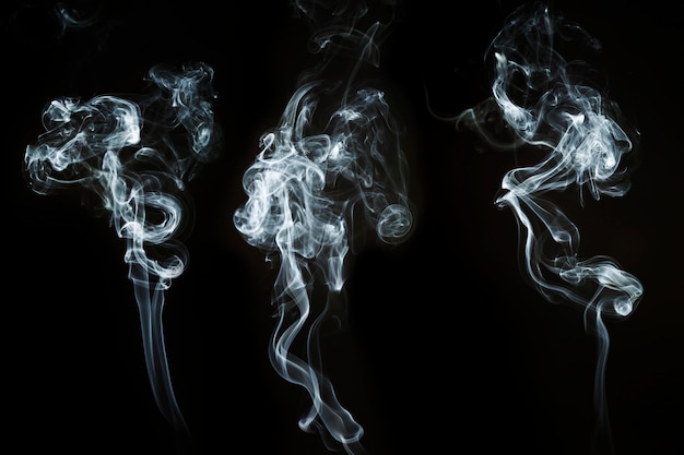 Three abstract shapes of white smoke