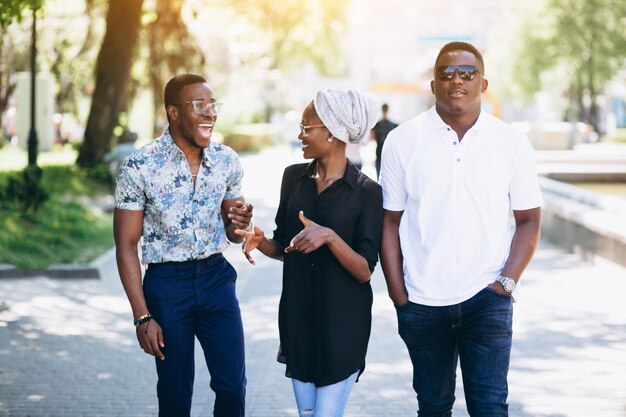 Three afican american people talking in the street