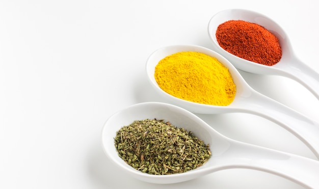 Three aligned spoons with spices powder