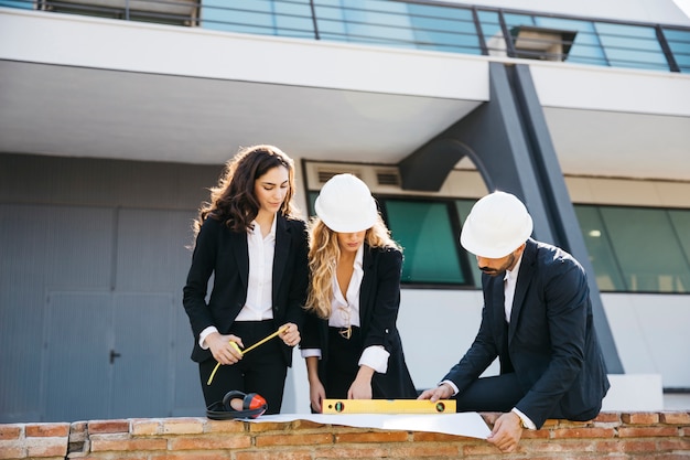 Free photo three architects wearing helmets