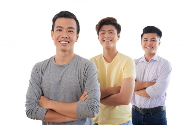 腕を組んで行に立って、カメラに笑顔の3つのアジア人の男性