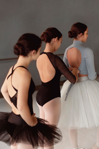 Free photo three ballerinas rehearsing in tutu skirts