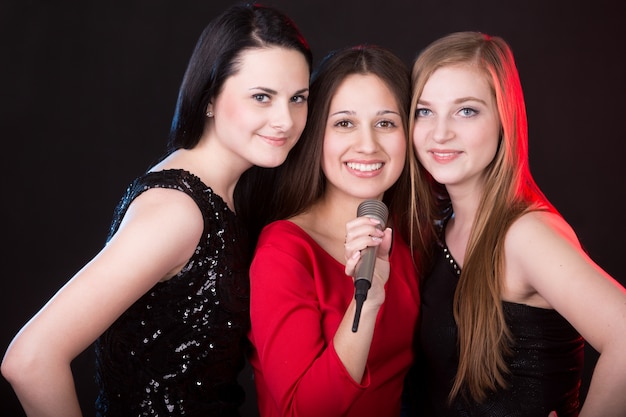 Три красивые девушки с микрофоном