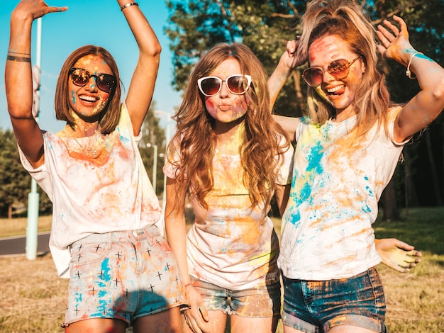 Three beautiful smiling girls posing at Holi party